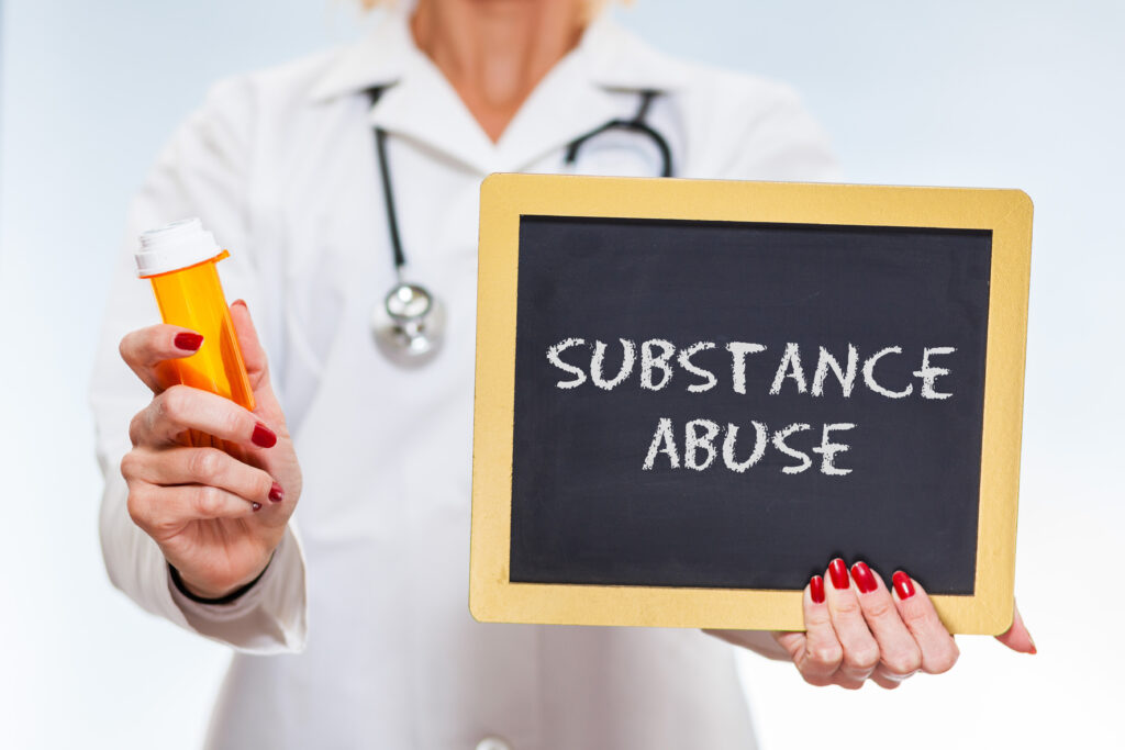 Doctor holding chalkboard sign that says substance abuse